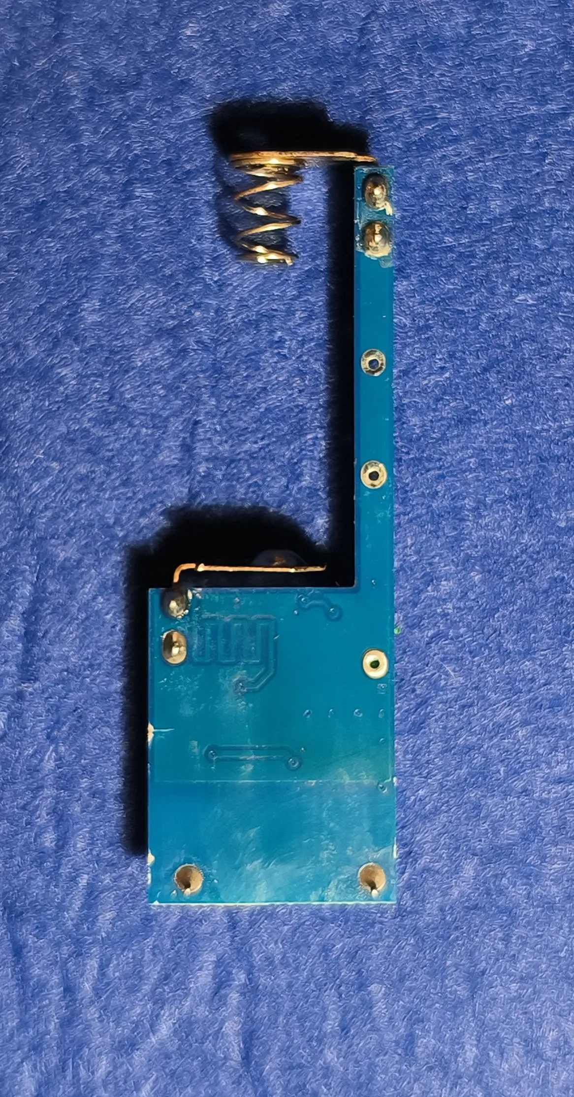 The back of the same PCB, mostly bare copper and solder pads
